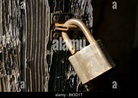 Entsperrt Vorhängeschloss auf einer alten Holztür Stockfoto