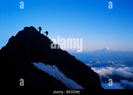 Zwei Kletterer Ansatz Gipfel der Turmspitze auf Mount Rainier in Mount Rainier Nationalpark, Washington. Mount Adams am Horizont. Stockfoto