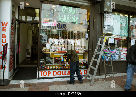 Arbeiter reinigt Frontscheibe ein Juweliergeschäft an der Market Street im Zentrum Stadt Philadelphia, PA Stockfoto