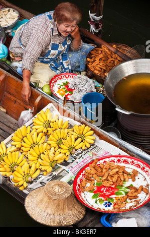 Verkauf von Lebensmitteln vom Boot in Damnoen Saduak Floating Market in Ratchaburi, Thailand Frau. Stockfoto