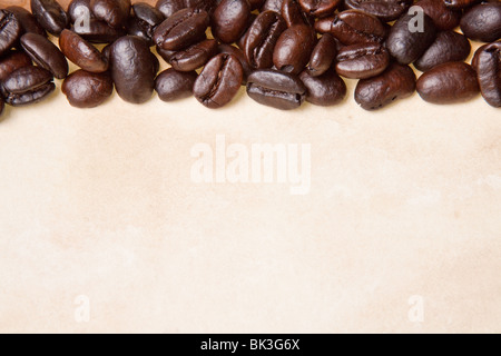 Kaffeebohnen auf einem Pergament-Papier-Hintergrund Stockfoto