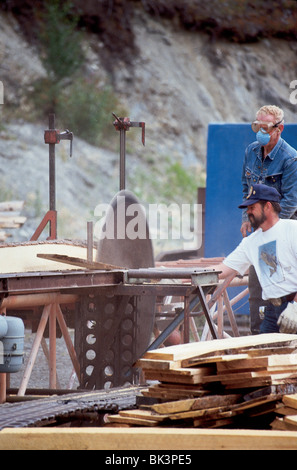 Zwei Männer, die in einem Freiluft-Sägewerk im Kenai Peninsula Borough in Cooper Landing, Alaska, arbeiten Stockfoto