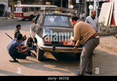Männer wechseln und fixieren einen Reifen auf einem Auto in Ägypten Stockfoto