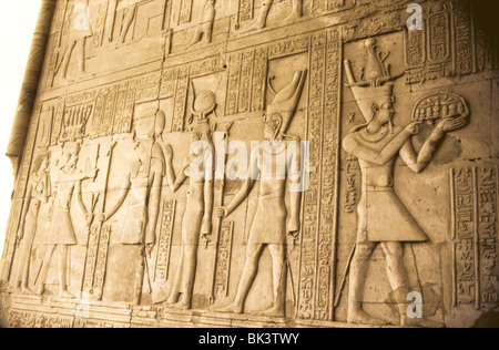Bas-Relief Wandskulptur mit menschlichen Figuren und ägyptischen Gottheiten an einer alten Ruinen, Ägypten. Stockfoto