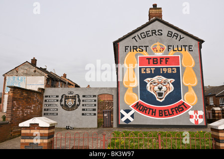 Wandbild für 'Tiger Bay erste Flöte' neben Gedenkstätte für Loyalisten aus der Gegend, die in den Unruhen getötet wurden. Stockfoto