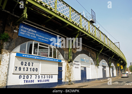 Kleinen Verglasung Geschäft befindet sich unter Bahnbögen in Pappel East London England UK Stockfoto