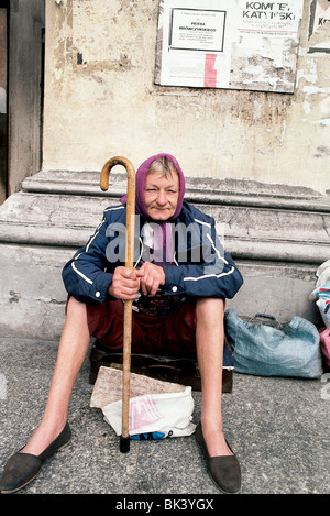 Portrait einer älteren Frau bitten um Geld mit einem Schild zu ihren Füßen, die besagt, dass sie krank ist & sie keine Mittel zur Herstellung hat einer Stockfoto