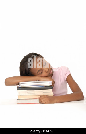 Zehn Jahre Alter Student stützte sich auf einen Stapel Bücher und einschlafen. Stockfoto