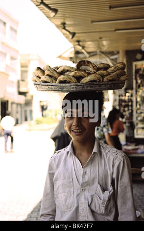 Ein junger Kaufmann mit einem Tablett mit Baqsam (Sesam bedeckt Brot-Sticks) zu verkaufen in Bagdad, Irak Stockfoto