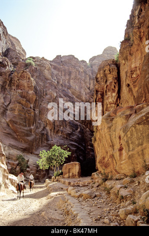 Zwei Personen auf dem Pferderücken in die al-Siq, der Haupteingang in die antike Stadt Petra im südlichen Jordanien Stockfoto