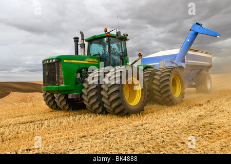 Ein Traktor ziehen einen Korn-Karren durchquert die Hügel der Palouse Region des östlichen Washingtion Stockfoto