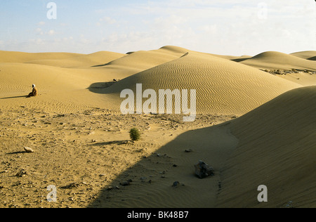 Ein Mann auf den Knien, abgewandt von der Sonne in der Sahara, LaYoune, Marokko Stockfoto