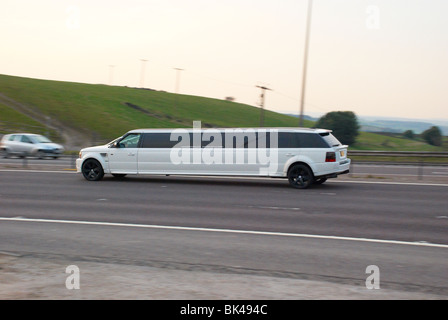 weiße Stretch-Limousine Range Rover auf der Autobahn. Stockfoto