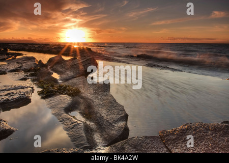 Contre Jour Bild auf den Sonnenuntergang über den Bristolkanal vom Kilve Strand. Stockfoto