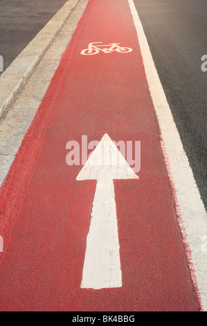 Helles Rot lackiert Radweg mit weißen Zyklus Symbol und einen Weg in Richtung Pfeil Stockfoto