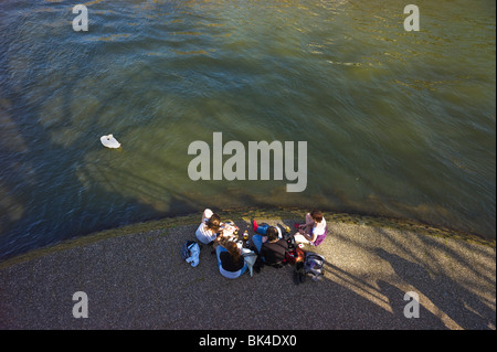 4 MÄDCHEN SITZEN AM UFER Stockfoto