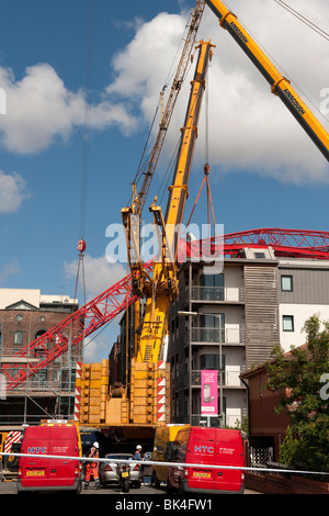 Turmdrehkran brach gefallenen auf Dach der Wohnblock wird von einem anderen Kran abgehoben Stockfoto