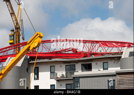 Turmdrehkran brach gefallenen auf Dach der Wohnblock wird von einem anderen Kran abgehoben Stockfoto