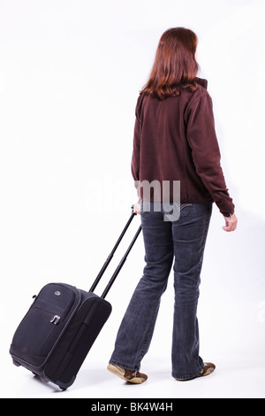 Frau Reisende ziehen einen Rollkoffer. Isoliert. Stockfoto