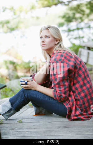 Frau Entspannung bei einer Tasse Kaffee, Kahshe See, Muskoka, Ontario, Kanada Stockfoto