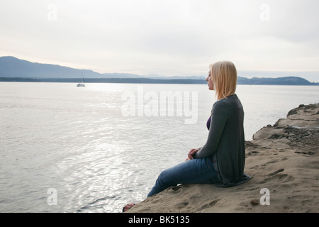 Frau sitzt am Strand, Vancouver, BC, Kanada Stockfoto