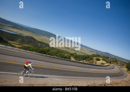 Frau mit ihrem Fahrrad bergab in Richtung Steamboat Springs, Routt County, Colorado, USA Stockfoto