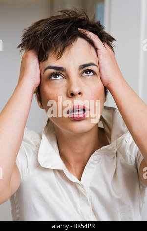 Frau hält ihren Kopf Stockfoto