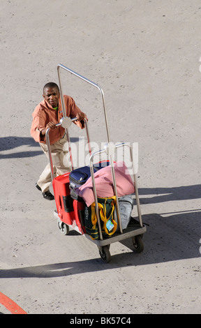 Hotelpagen eine Gäste-Gepäck auf seinem Wagen schieben Stockfoto