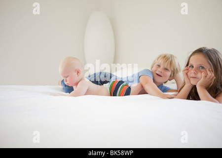 Geschwister, Faulenzen am weißen Bett Stockfoto