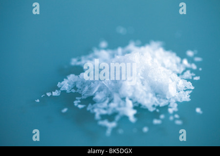 Meer Salz Flocken in einem kleinen Stapel auf ein Glas Tabelle mit den Details der Flake von Salz Stockfoto