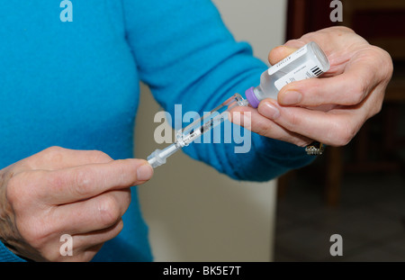 Tierbesitzer, die Vorbereitung einer Dosis von Insulin aus der Flasche mit einer Injektionsnadel die Dosis wird zu einem diabetischen Hund verabreicht werden Stockfoto