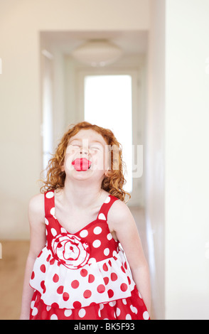 Mädchen in rot-weiß gepunkteten Kleid mit großen Lippen Stockfoto