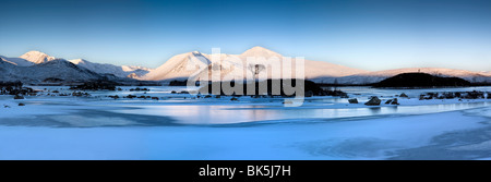 Winter-Ansicht im Morgengrauen über gefrorene Lochain Na h'Achlaise nach sonnenverwöhnten Mount Black Hills, Rannoch Moor, Highland, Schottland Stockfoto