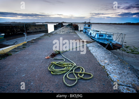 Beadnell Hafen bei Sonnenuntergang zeigt alte Seil aufgewickelt auf Hafenpromenade und baufällig Fischerboot, Beadnell, Northumberland, England Stockfoto