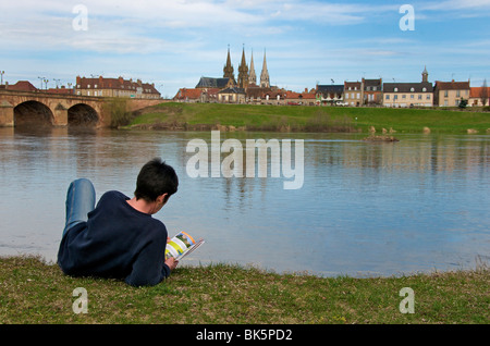 Frau im liegen am Ufer des Allier vor der Stadt Moulins. Auvergne. Frankreich. Stockfoto