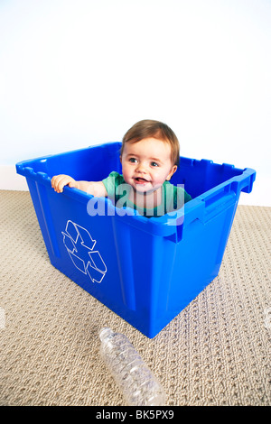 Babymädchen in Recyclingbehälter Stockfoto