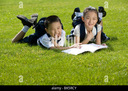 Grundschüler lesen auf dem Rasen Stockfoto
