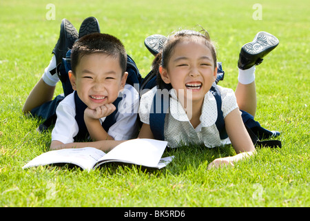 Grundschüler lesen auf dem Rasen Stockfoto