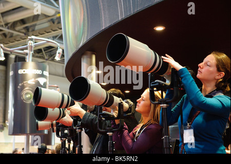 Foto-Enthusiasten untersuchen eine Reihe von Canon-Objektive auf einer Messe im NEC, Birmingham, England Stockfoto