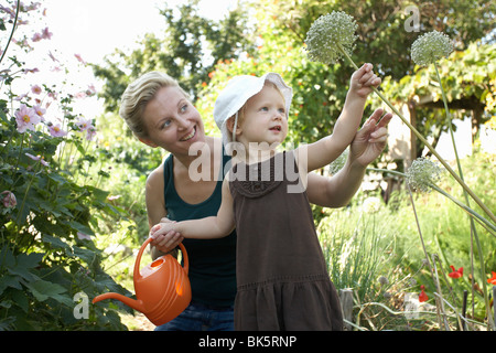 Mutter und Tochter im Garten Bewässerung Pflanzen Stockfoto