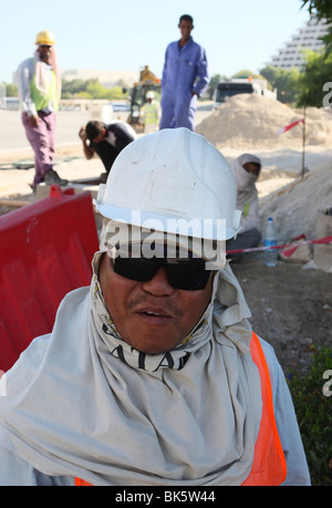 Bauarbeiter tragen Schutzkleidung, Helm und Sonnenbrille in Doha, Katar, Nahost Stockfoto