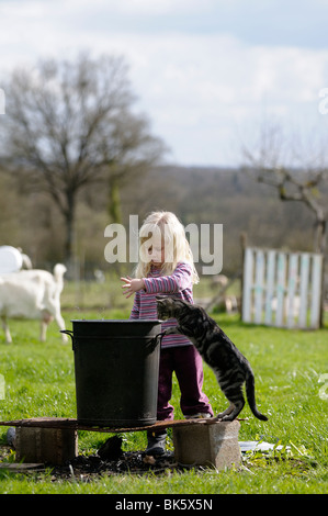 Stock Foto eines vier Jahre alten Kindes spielen Spiele im Garten mit ihrer Katze zu glauben machen. Stockfoto