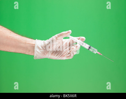Medizinischen Handschuhen mit Spritze und Nadel mit männlichen Arm im Querformat Stockfoto