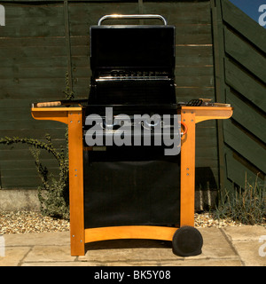 Eigenständiger Gasgrill, Grill, Grill, in einer Gartenumgebung auf einer Terrasse mit grünem Zaun. Perfekt für Familien und Freunde. Stockfoto