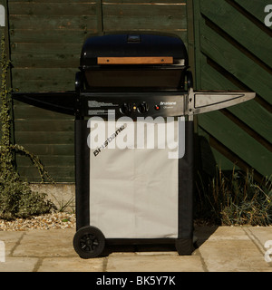 Eigenständiger Gasgrill, Grill, Grill, in einer Gartenumgebung auf einer Terrasse mit grünem Zaun. Perfekt für Familien und Freunde. Stockfoto