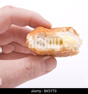 Hand hält die Hälfte gegessen Donut vor weißem Hintergrund. Stockfoto