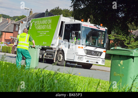 Einer gasbetriebenen Mercedes Econic Müllabfuhr LKW und bin Müllmänner in einer Wohnstraße Stockfoto