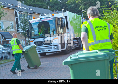 Einer gasbetriebenen Mercedes Econic Müllabfuhr LKW und bin Müllmänner in einer Wohnstraße Stockfoto