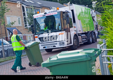 Einer gasbetriebenen Mercedes Econic Müllabfuhr LKW und bin Müllmänner in einer Wohnstraße Stockfoto