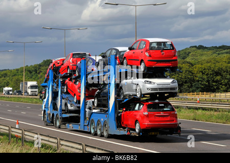 Pkw-Transporter LKW-Lkw-Großmobil und Sattelanhänger beladen mit neuen Autos, die auf der M25-Kreisautobahn Essex England Großbritannien fahren Stockfoto